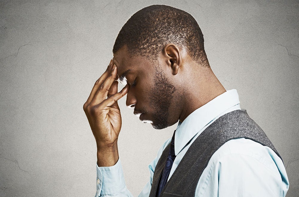 man with hand to his temple