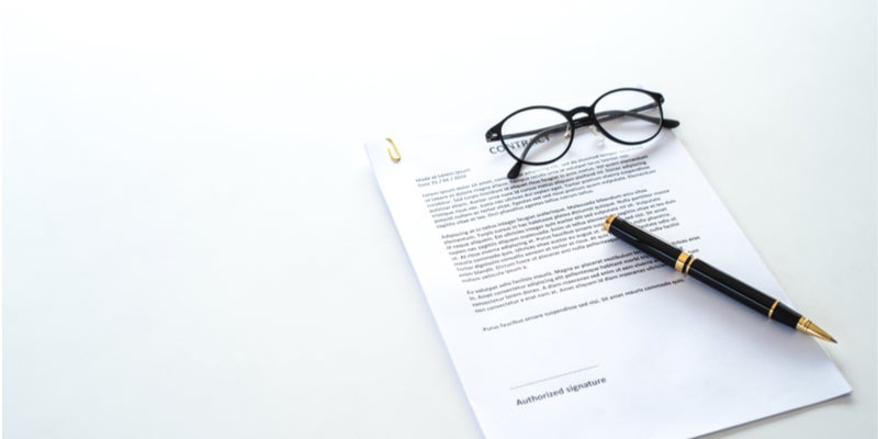 contract on table with glasses and pen