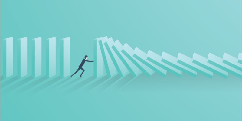 a man stopping blocks from falling like dominos