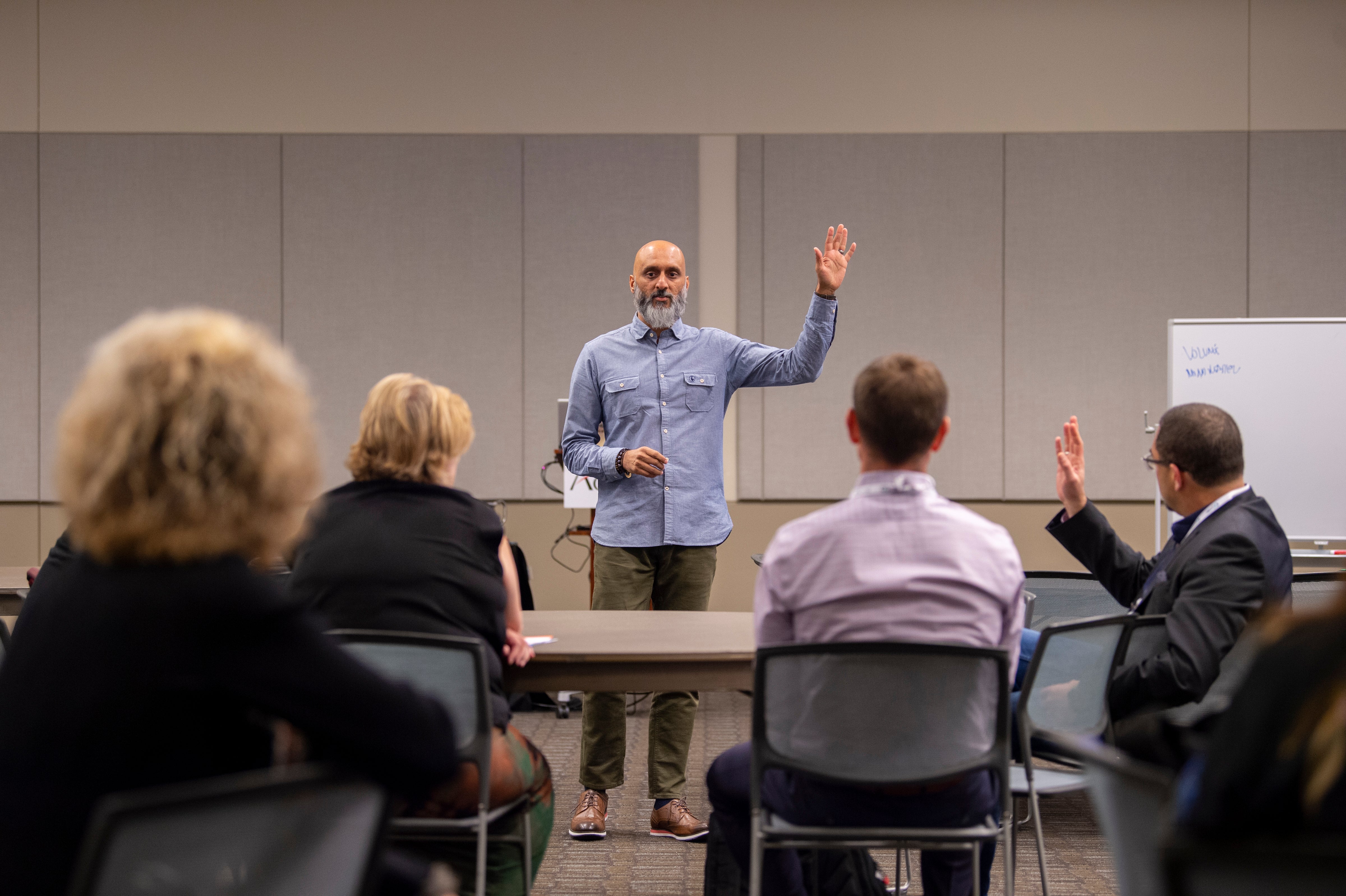 instructor raising hand asking question for attendees to also raise hand