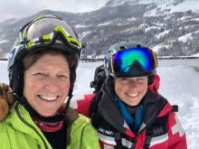 Two women in ski gear taking a selfie on a mountain